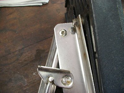 Cracked welds on the hinge pins and elongated holes in the mount plates